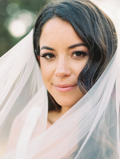 Close up portrait of a bride with her veil around her face