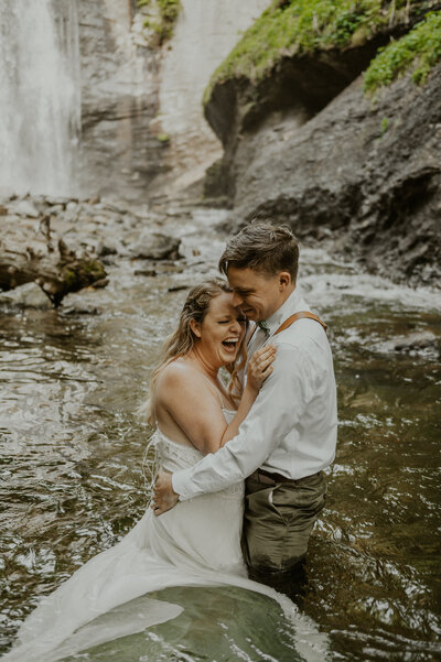 Couple holding each-other in a river during their Colorado elopement.
