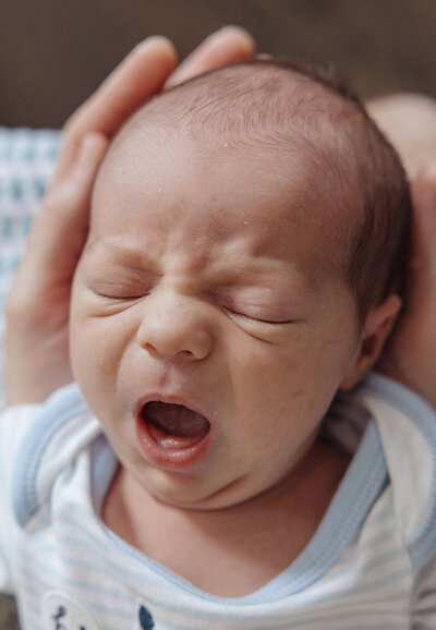 Tired newborn baby during photo session in Chicago, IL