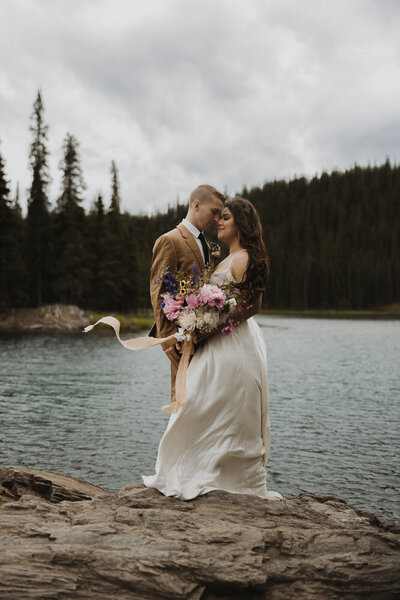 bride and groom holding hands in front of a mountain