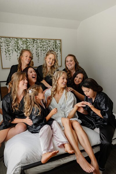 Bride in the middle with her bridal party surrounding her laughing with joy