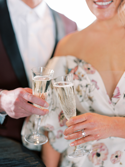 bride and groom clicking champagne glasses