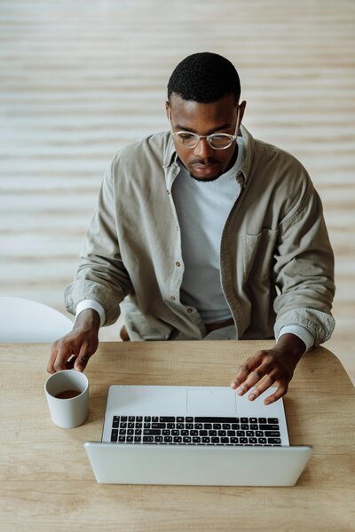 Man working on a Macbook wearing a green shirt