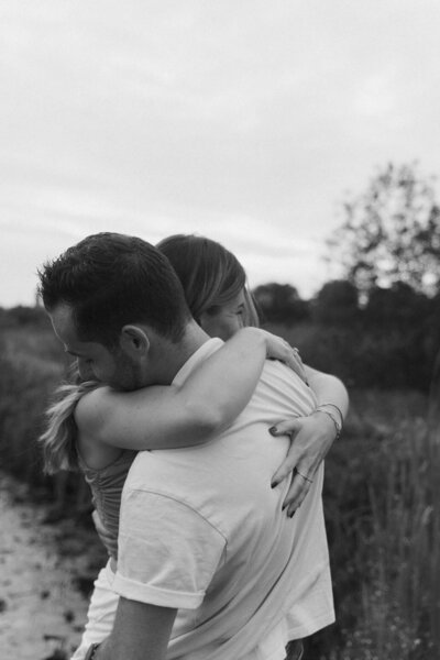 Een man en een vrouw zitten op een bankje. De man zit lager dan de vrouw waardoor er een hoogteverschil is wat de foto diepte geeft. Beiden kijken ze een andere richting op.