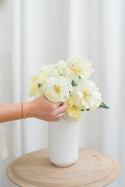 photographers columbus ohio captures floral detail photo of person placing the white florals in a vase