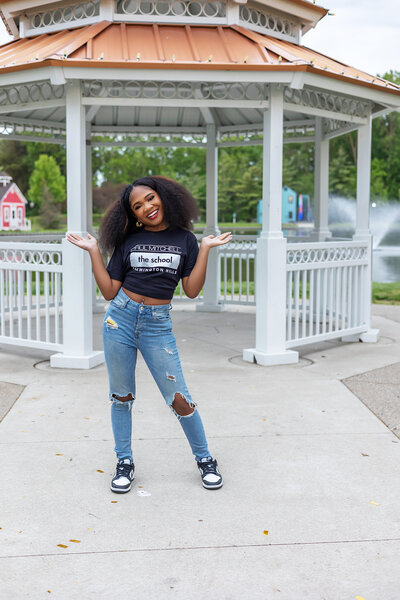 Senior girl standing in front of gazebo posing playfully