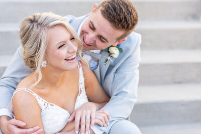 bride and groom laughing on stairs