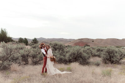 bride and groom embracing in desert