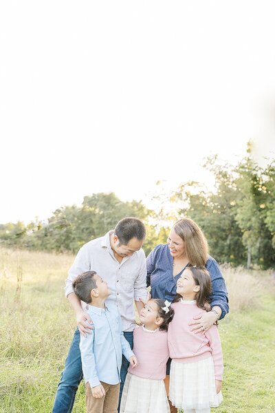 family laughs together during family photo session in Wellesley Massachusetts