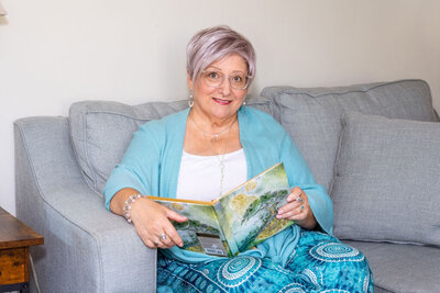 April sits on the couch holding a book