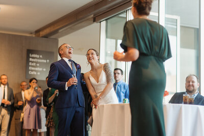 Bride and groom laughing during toasts at Contemporary Art Museum