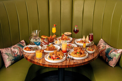A table spread of food at Stuffed Brunch in Columbai, SC featuring many menu items at a green leathered booth.