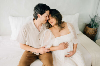 pregnant woman in colorful dress leaning into bed