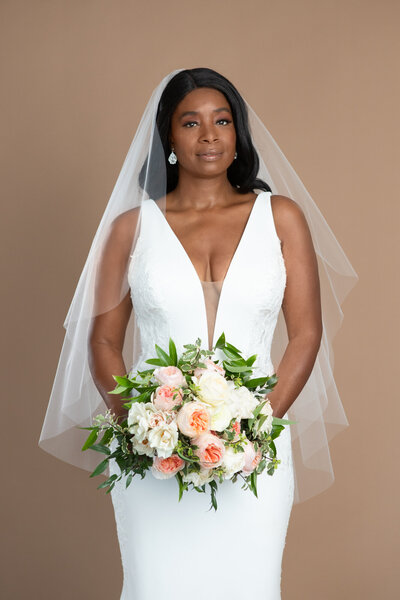 bride wearing a short two layer veil with waterfall shape and holding a bouquet