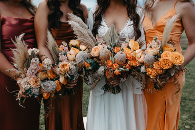 bridesmaids and bride with their vibrant autumn coloured bouquets