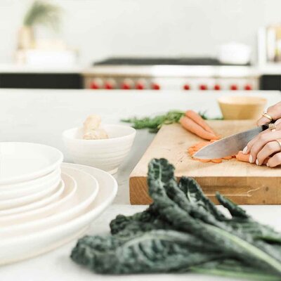Chopping carrots, kale in foreground