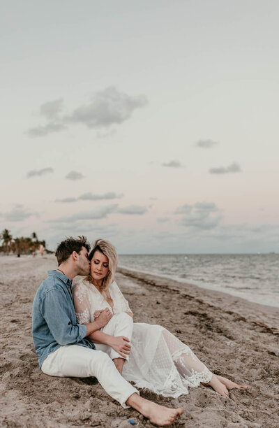 beautiful couple cuddling on beach during sunset on delaware beach engagement photography