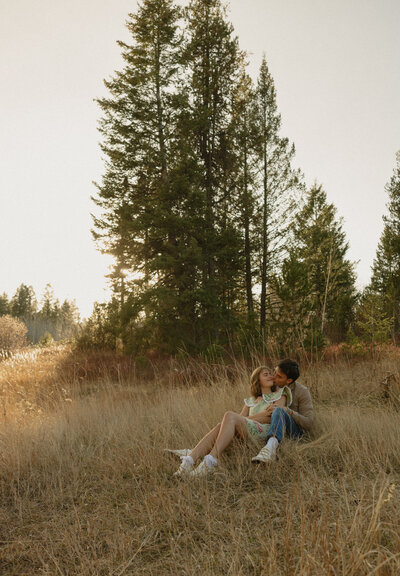 A couple standing in a lake with the water waist high. They are holding and looking at each other, smiling.