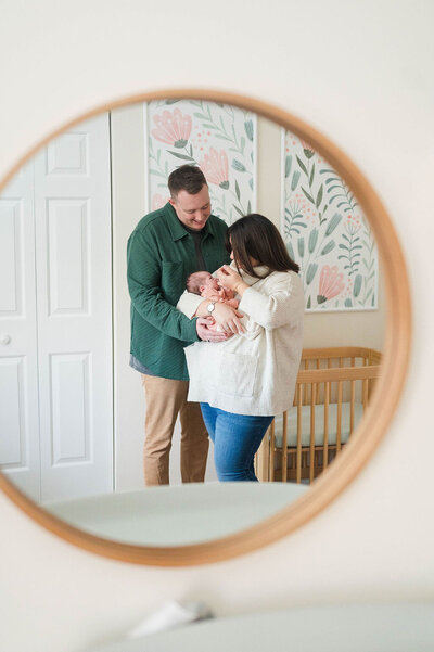 Best newborn photographer in Rhode Island shot of mom and dad looking at baby through mirror