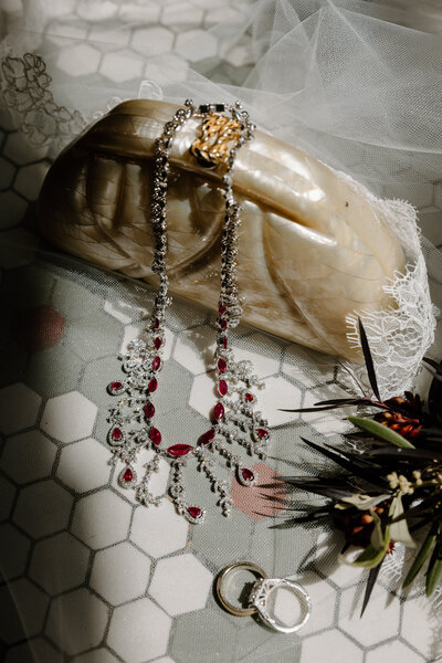 Jewelry laid over a small purse. 