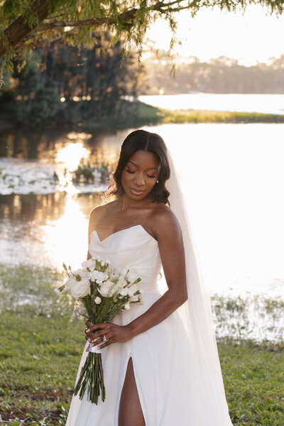 indie west portfolio image of bride kissing grooms hand next to beach