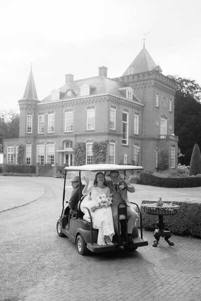 Getrouwd koppel op golfkar voor kasteel, gefotografeerd door trouwfotograaf Julia de Groot uit Utrecht