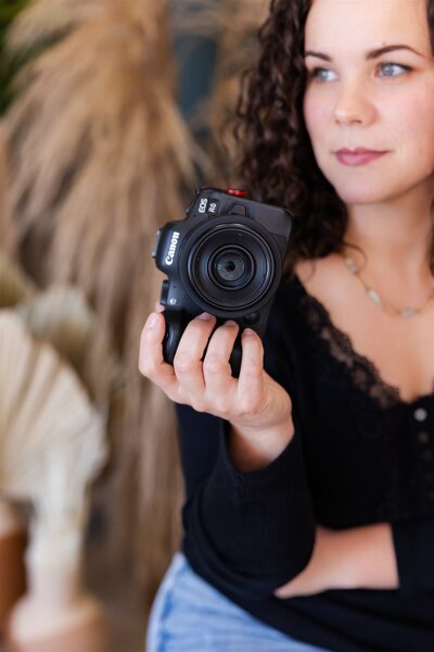 Colorado Springs Boudoir Photographer holding camera while looking away