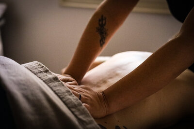 Massage Therapist working on the lower back of a client