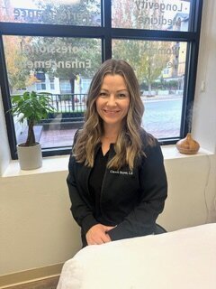 Caucasian woman smiling in front of an esthetician table in a spa room