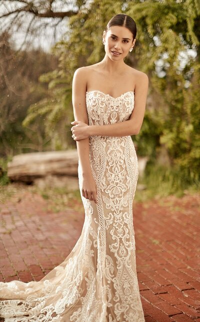 This sleeveless column sheath features sheer illusion netting adorned with bold lace appliques.