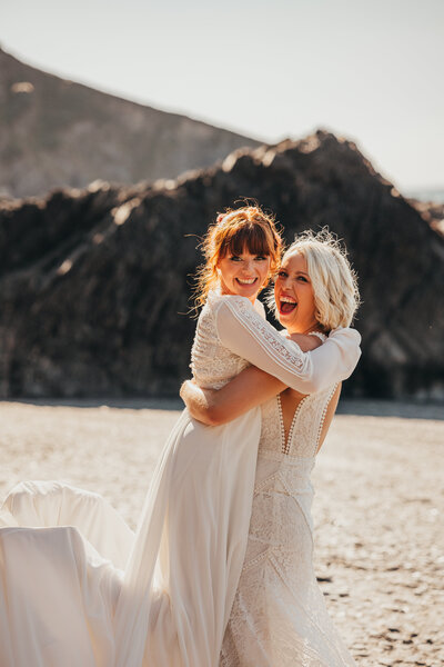 LGBTQ+ female couple embrace during their wedding day