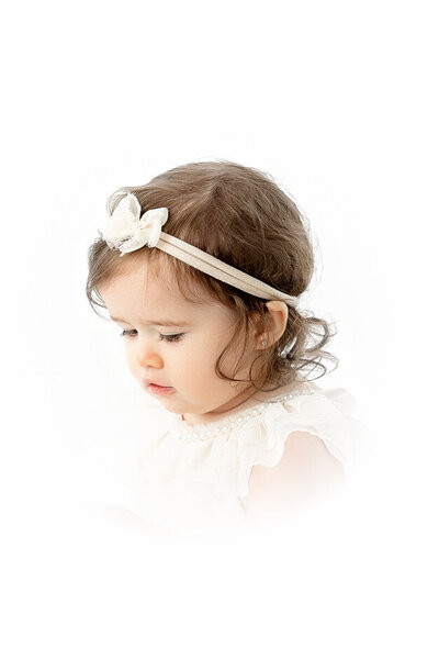 Happy baby sitting in all white studio for Heirloom Portrait I Fresno CA with baby photographer angelia jansen of One Good Shot Photography
