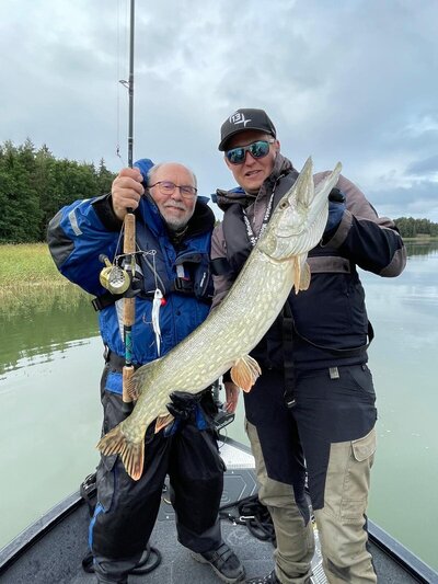 Kalastusopas j asiakas esittelevät isoa haukea, jonka he ovat kalastaneet