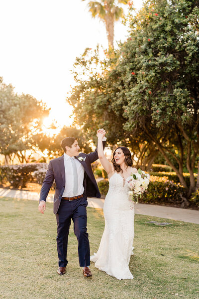 Bride and Groom standing on staircase with long dress at La Valencia wedding venue