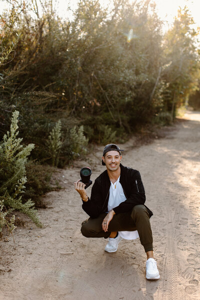 Orange County wedding photographer smiling standing in front of building