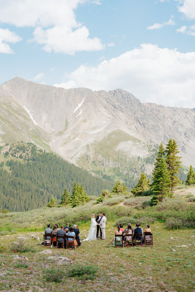Bride and groom exchange vows during intimate mountain wedding ceremony in Colorado
