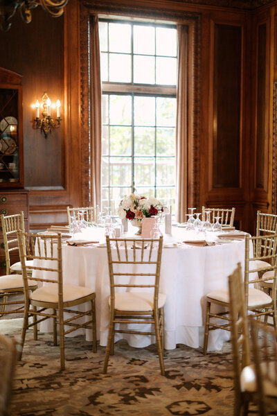 November wedding at Graylyn Estate, designed and planned by Charming Carolina — indoor dinner table setup with white linens and a floral centerpiece in the manor house.