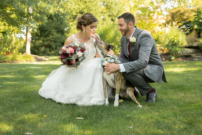 Bride her groom enjoy a special moment with their pup on their wedding day in Solon, Ohio. Photo taken by Aaron Aldhizer