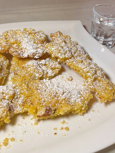 A plate of sbrisolona cookies dusted with powdered sugar