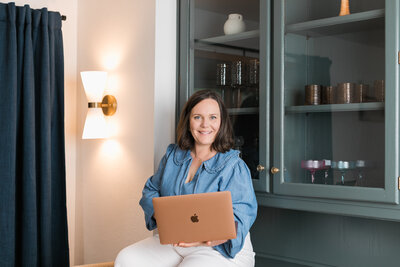 a woman working at a laptop with a glass of wine