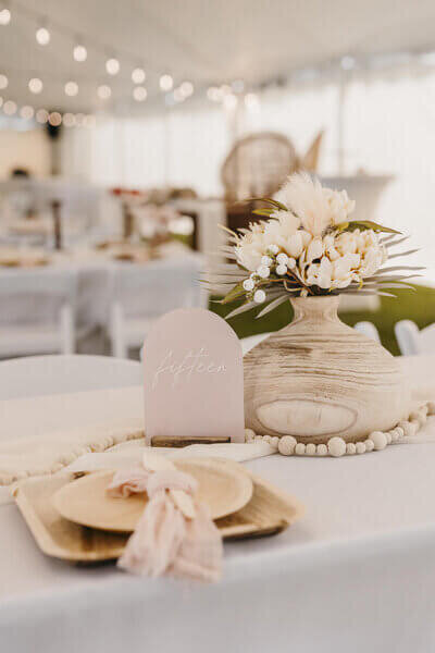 Floral arrangement next to wooden details at a private estate wedding reception in Fon du Lac Wisconsin by milwaukee wedding planner.