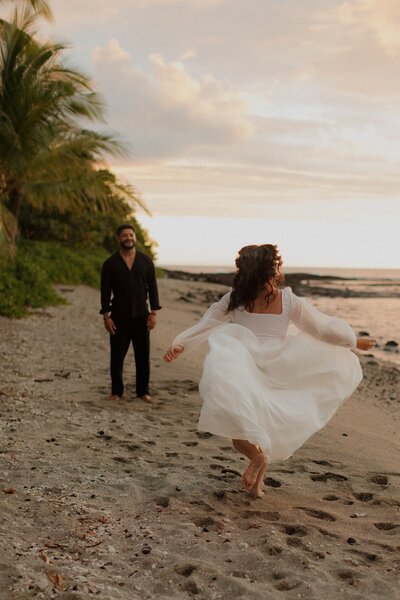 bride running towards groom on beach in hawaii