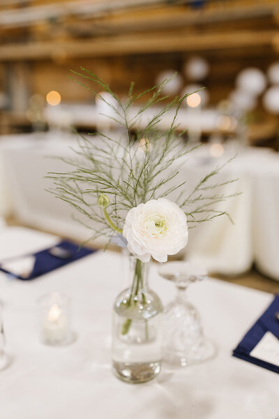 Event Centerpiece with vase, a white flower, and small candles