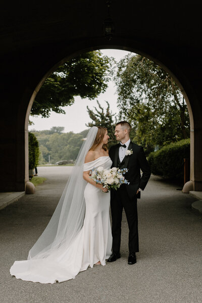 bride and groom under arch at Ocean Cliff Hotel