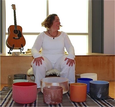 Women in white with sound healing bowls on the floor