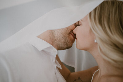 couple kissing under sheer bridal veil