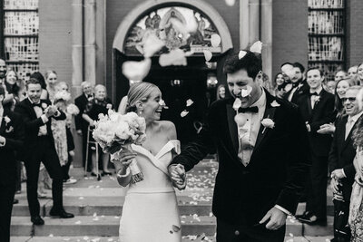 bride and groom showered in rose petals as they exit church ceremony 