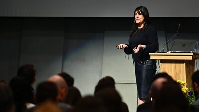 Kristin Skinner delivering a keynote presentation on organizational systems and leadership.