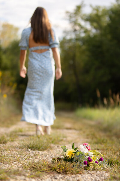 Flowers left on trail as senior girl walks away