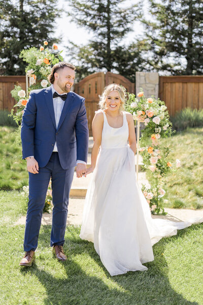 a bride and groom walk and laugh together at their cornerstone gardens wedding in sonoma, ca